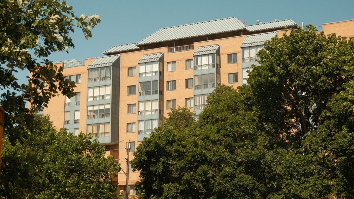 A mid-rise apartment building among mature trees